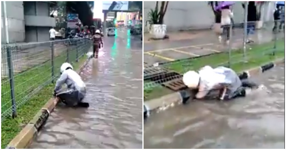 Watch: Dedicated KL Police Unclogs Drain Using His Own Hand During Flash Flood - WORLD OF BUZZ
